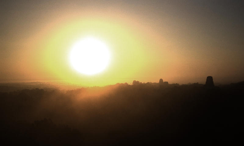 a bright morning sun over the temples at Tikal, Guatemala